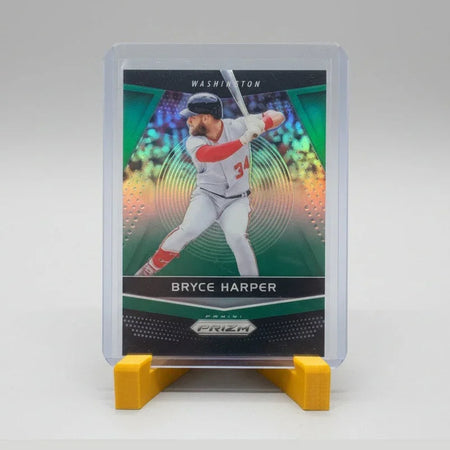Baseball trading card of Bryce Harper in a clear case on a textured surface