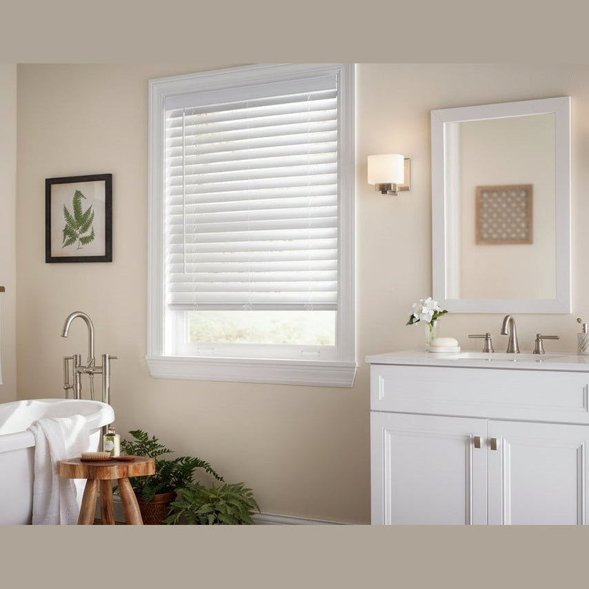 Bathroom interior with a window featuring white blinds, sink, and bathtub.