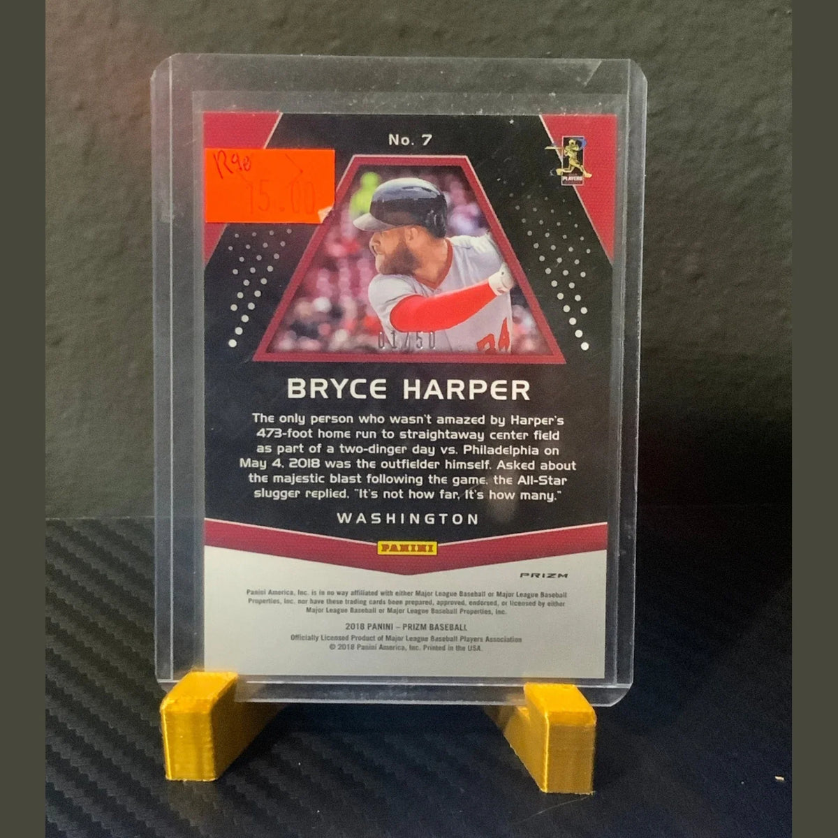Baseball trading card of Bryce Harper in a clear holder on a dark surface