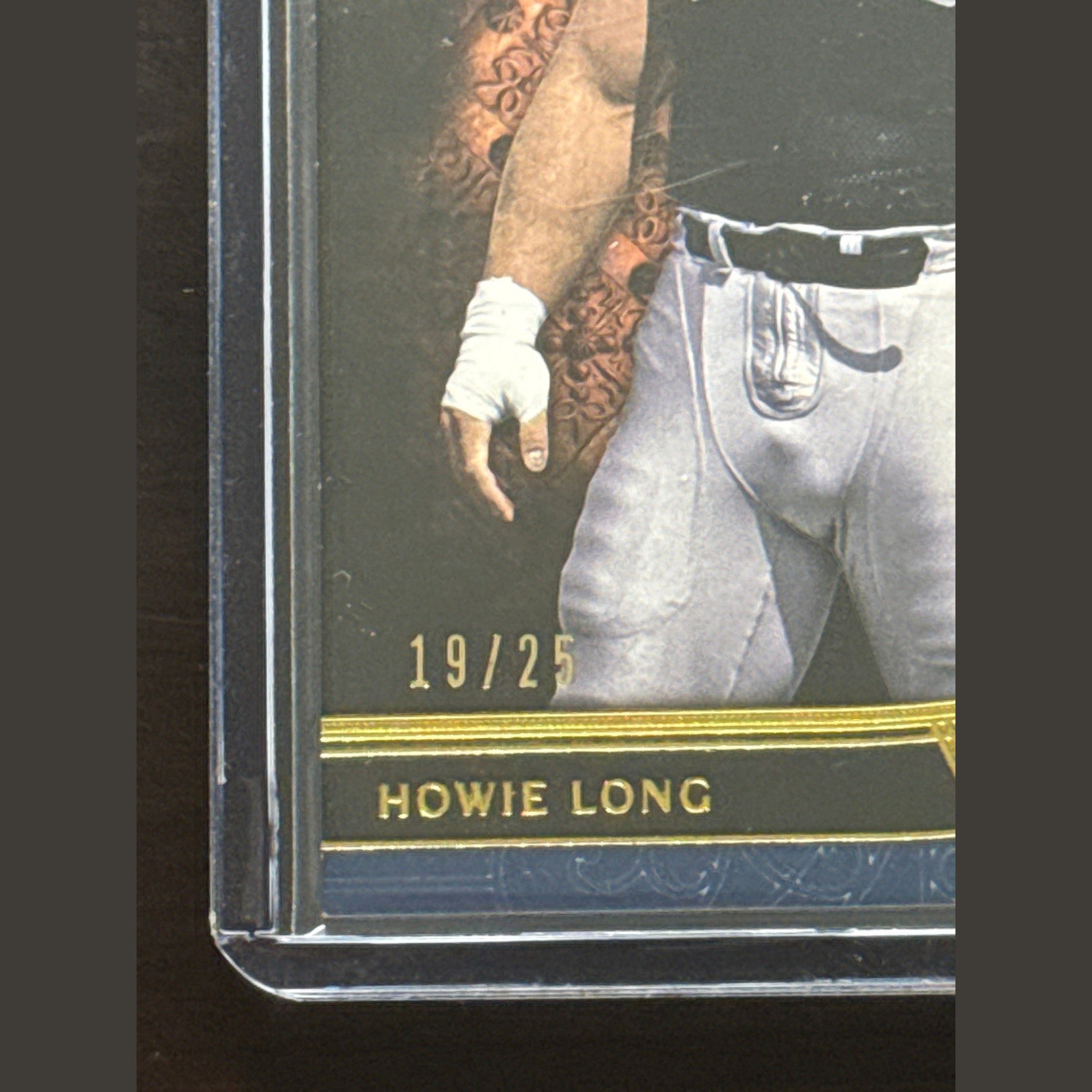 Close-up of a sports trading card featuring a person with tattoos on an arm, wearing a white glove.