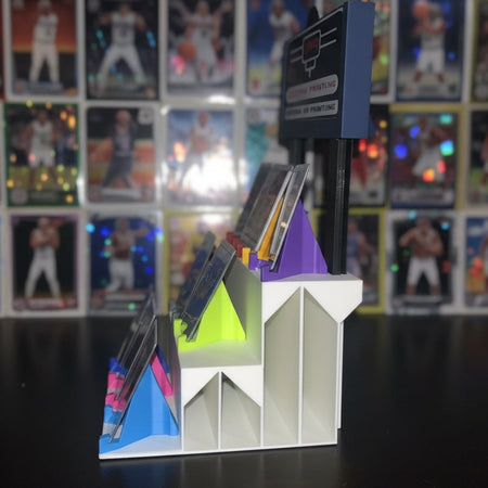 3D printer in operation with colorful plastic pieces on a dark background