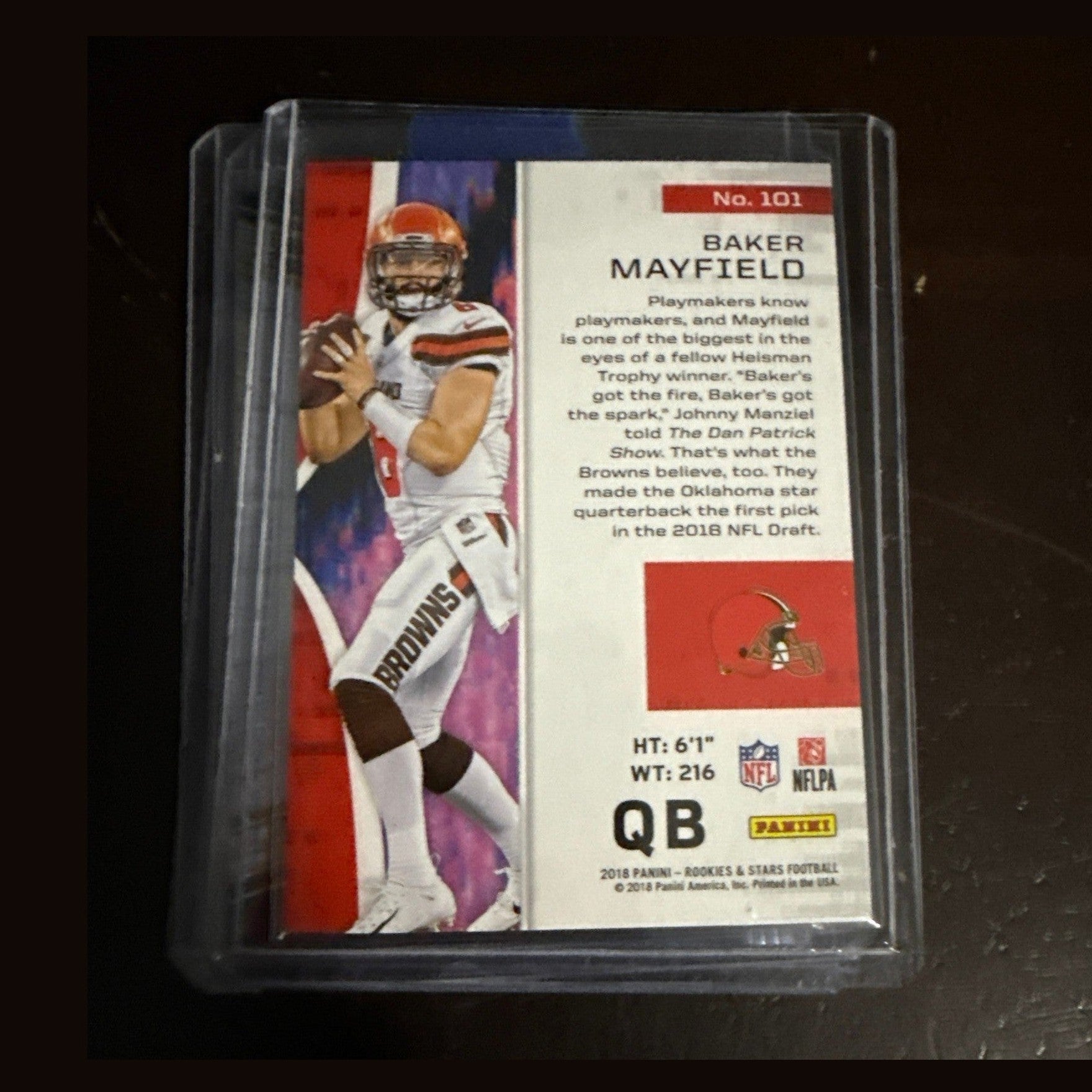 Football trading card of a quarterback in a clear protective case on a dark surface