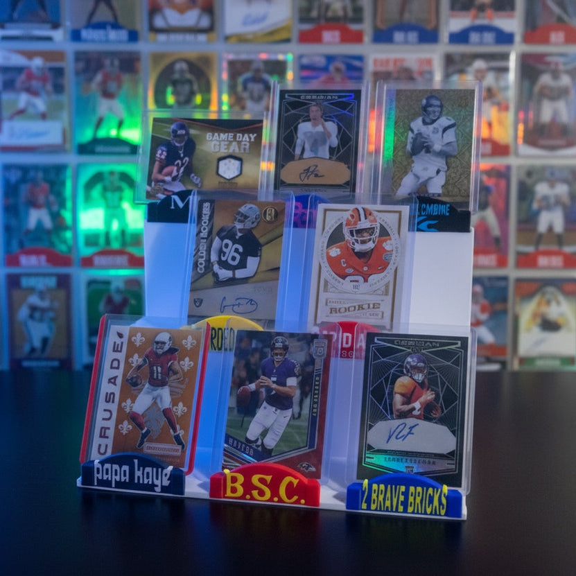 Collection of sports trading cards in a display case on a dark surface.