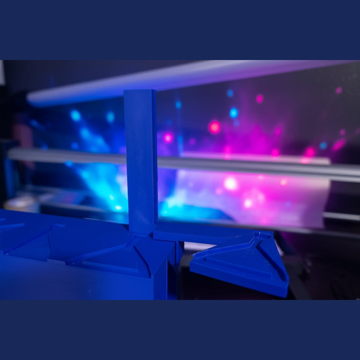 Blue plastic component attached to a machine with a dark background