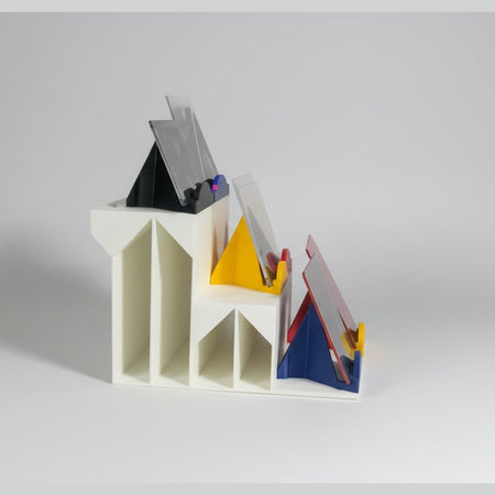 White 3D-printed staircase model on a black surface with a gray wall background