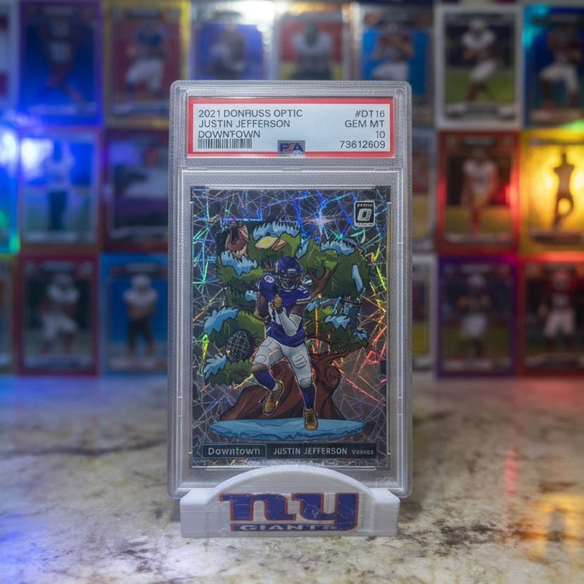 Trading card in a holder with 'PSA' grading on a blurred background of sports memorabilia