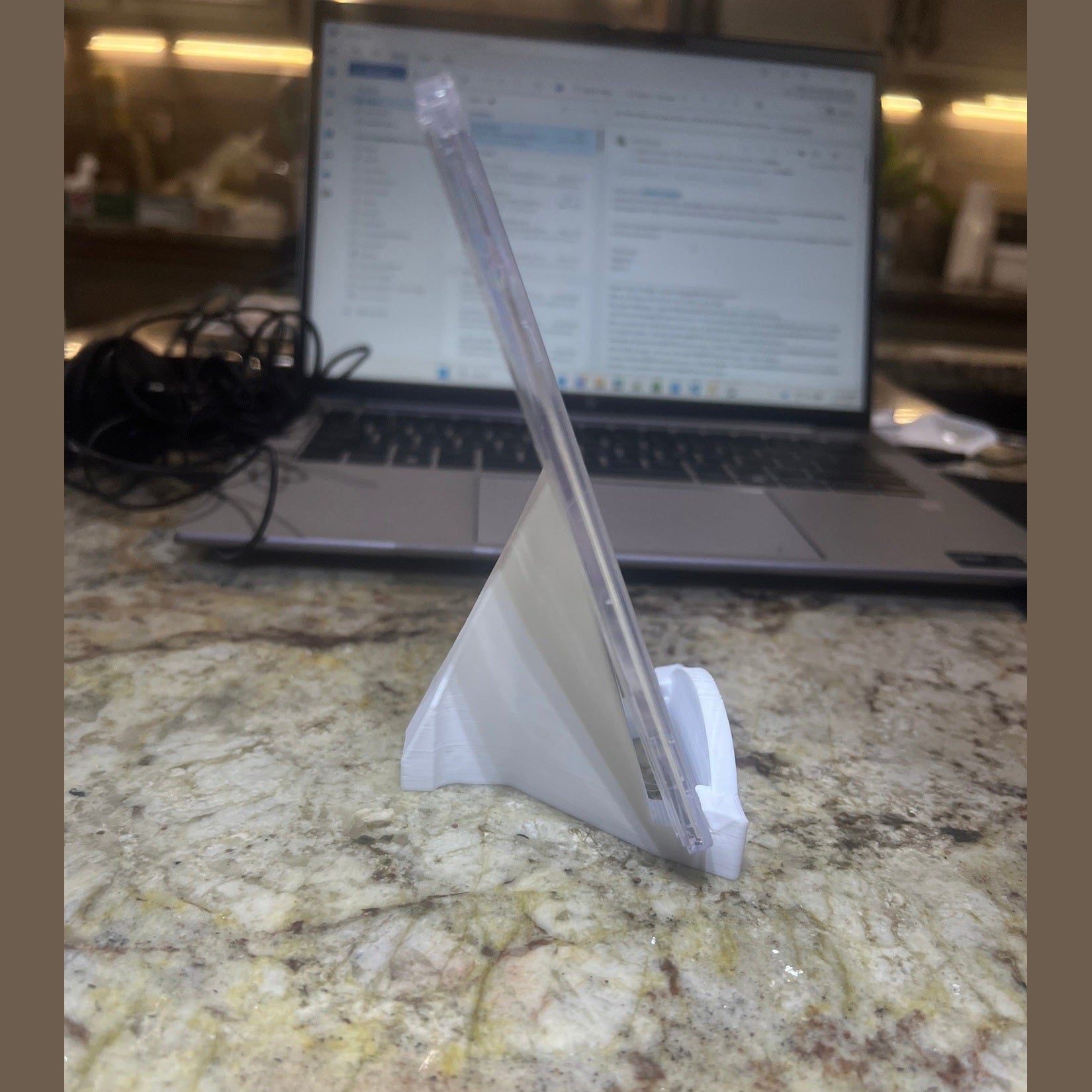 Laptop on a marble surface with a piece of paper on top