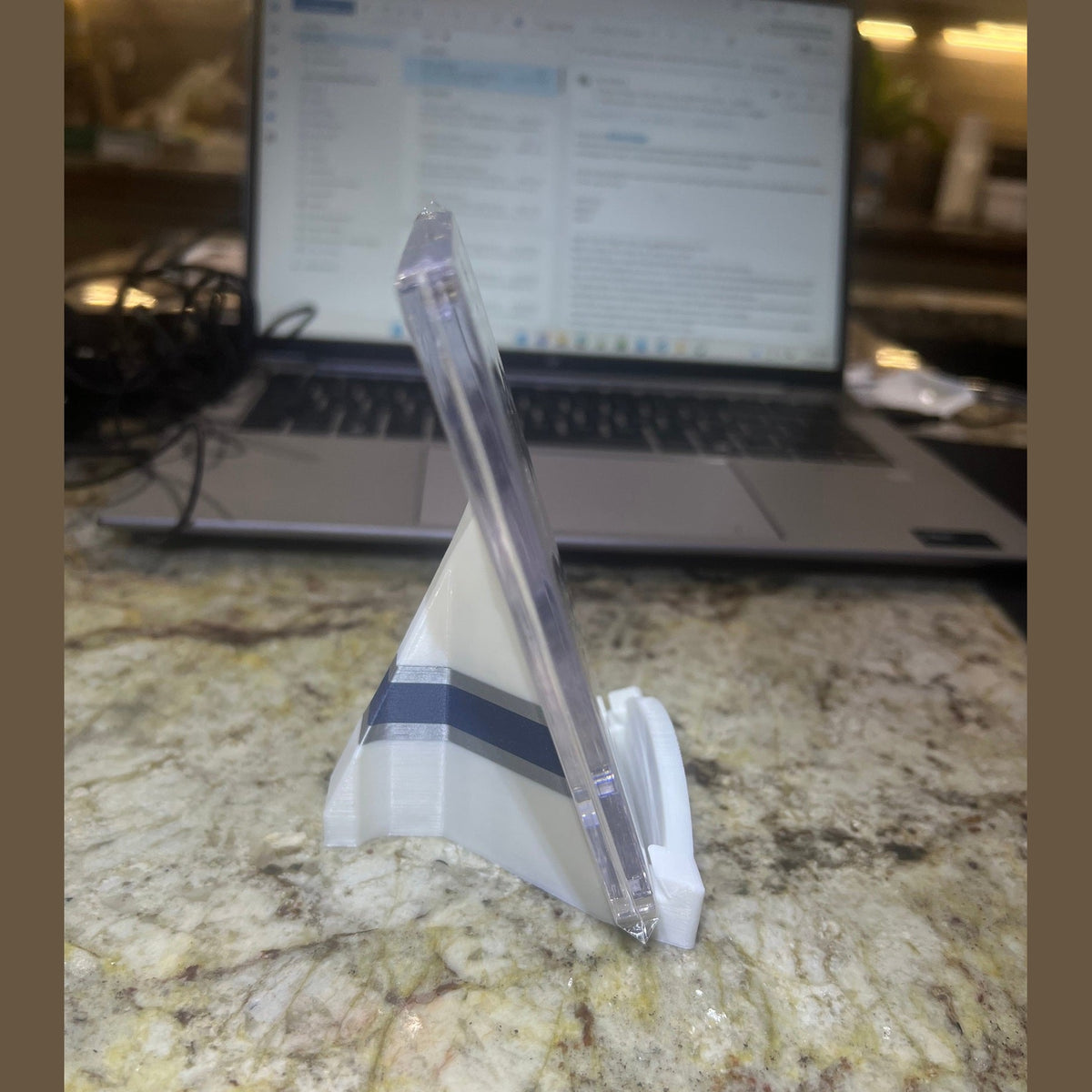 Clear plastic knife on a marble surface with a blurred laptop in the background