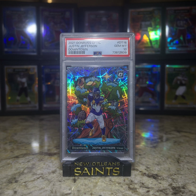 Trading card in a protective case with New Orleans Saints branding on a countertop.