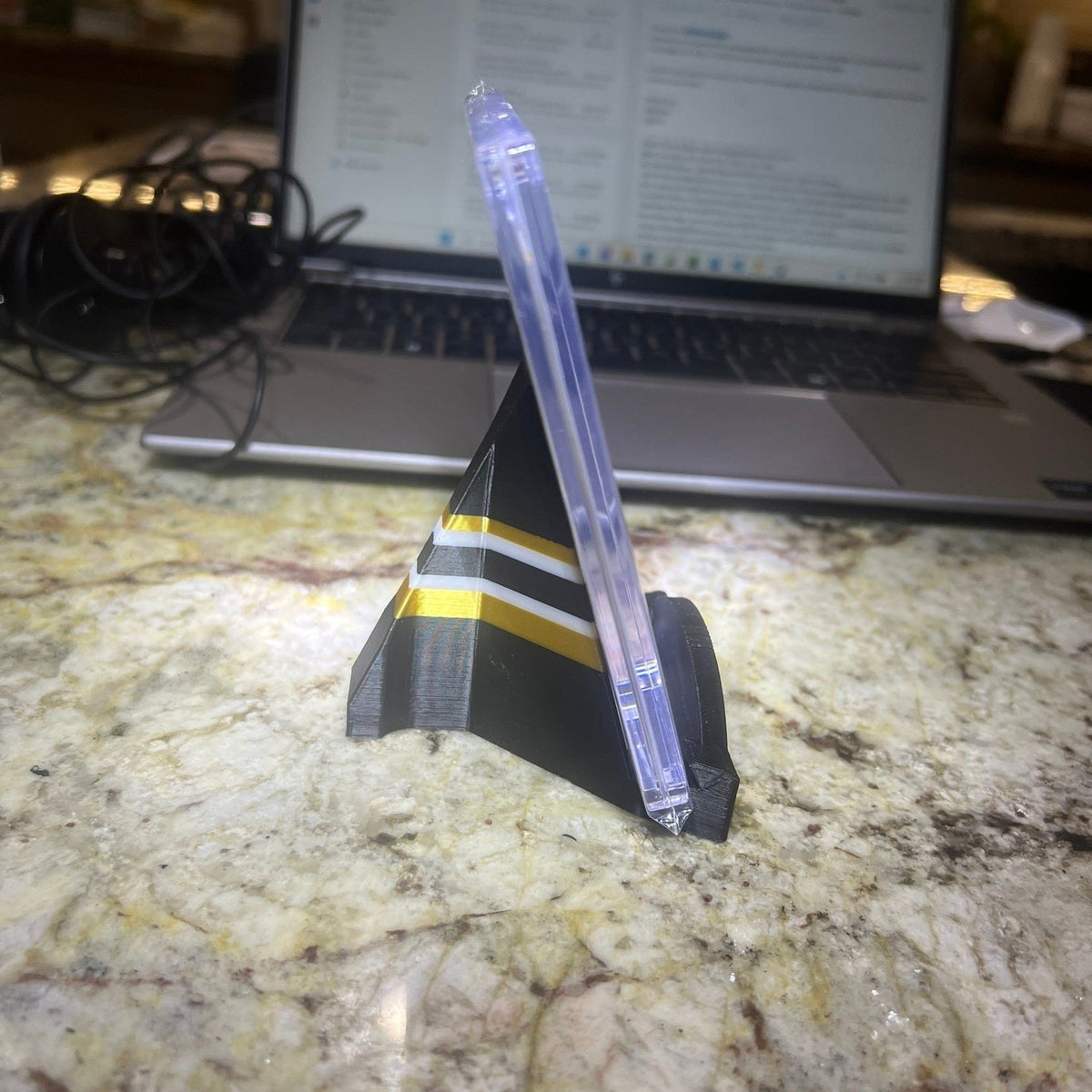 Model rocket on a marble surface with a laptop in the background