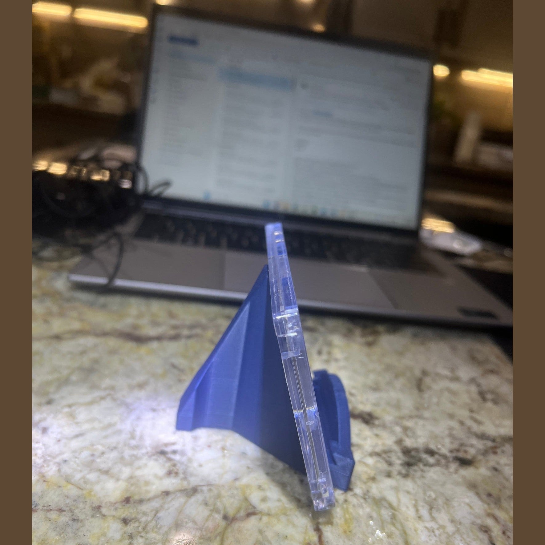 Blue plastic component on a marble surface with a blurred screen in the background