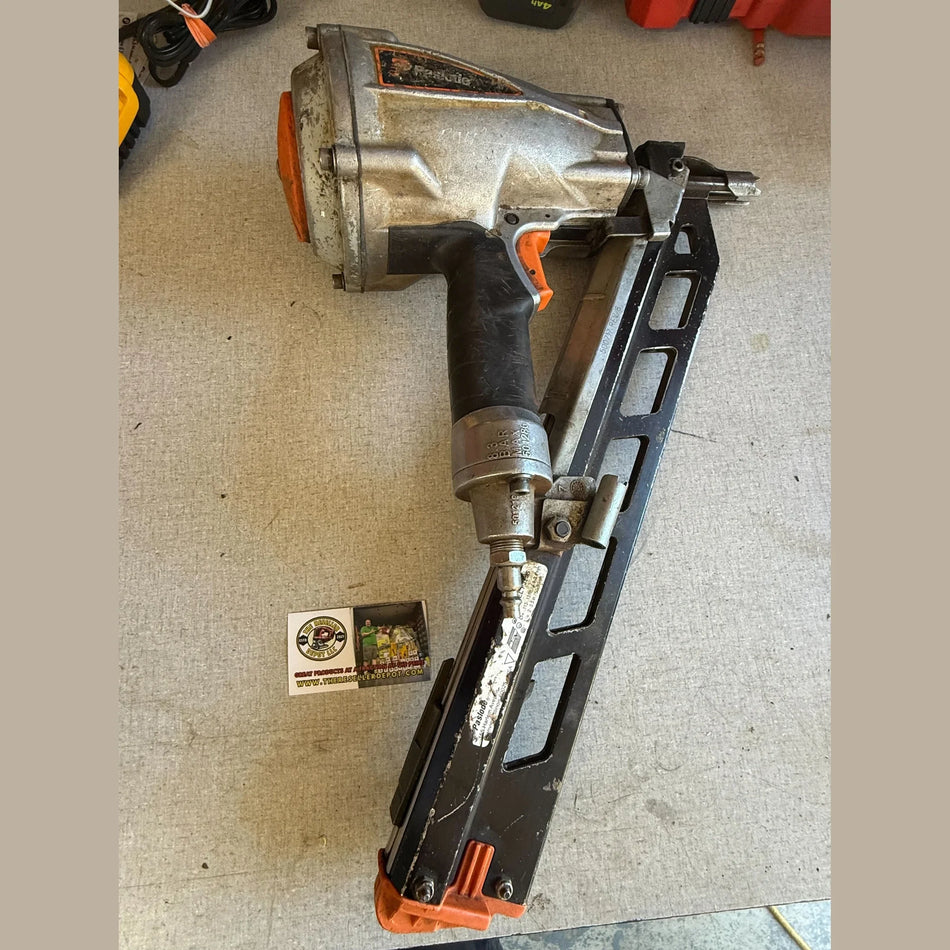 Nail gun on a textured surface with a small box nearby