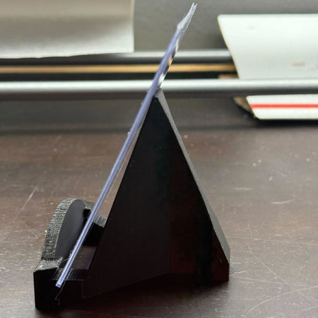 Black paper cutter on a desk with office supplies in the background