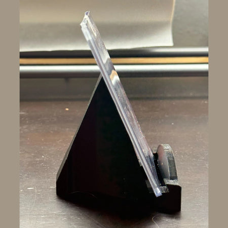 Clear ruler on a black stand against a neutral background