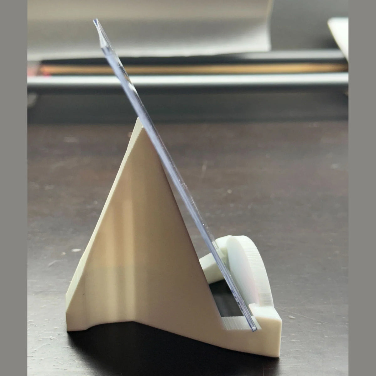 Clear ruler on a beige stand against a dark background