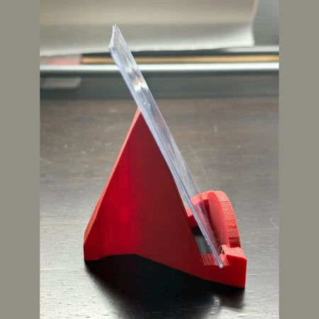 Red plastic tool with a clear blade on a metallic surface