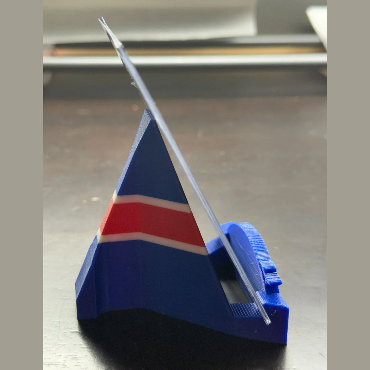 Blue plastic stand with a red and white striped object on a metallic surface