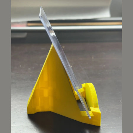 Clear ruler on a yellow stand against a metallic background