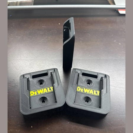 Two DEWALT tool attachments on a metallic surface