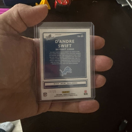 Hand holding a trading card of D'Andre Swift from the Detroit Lions