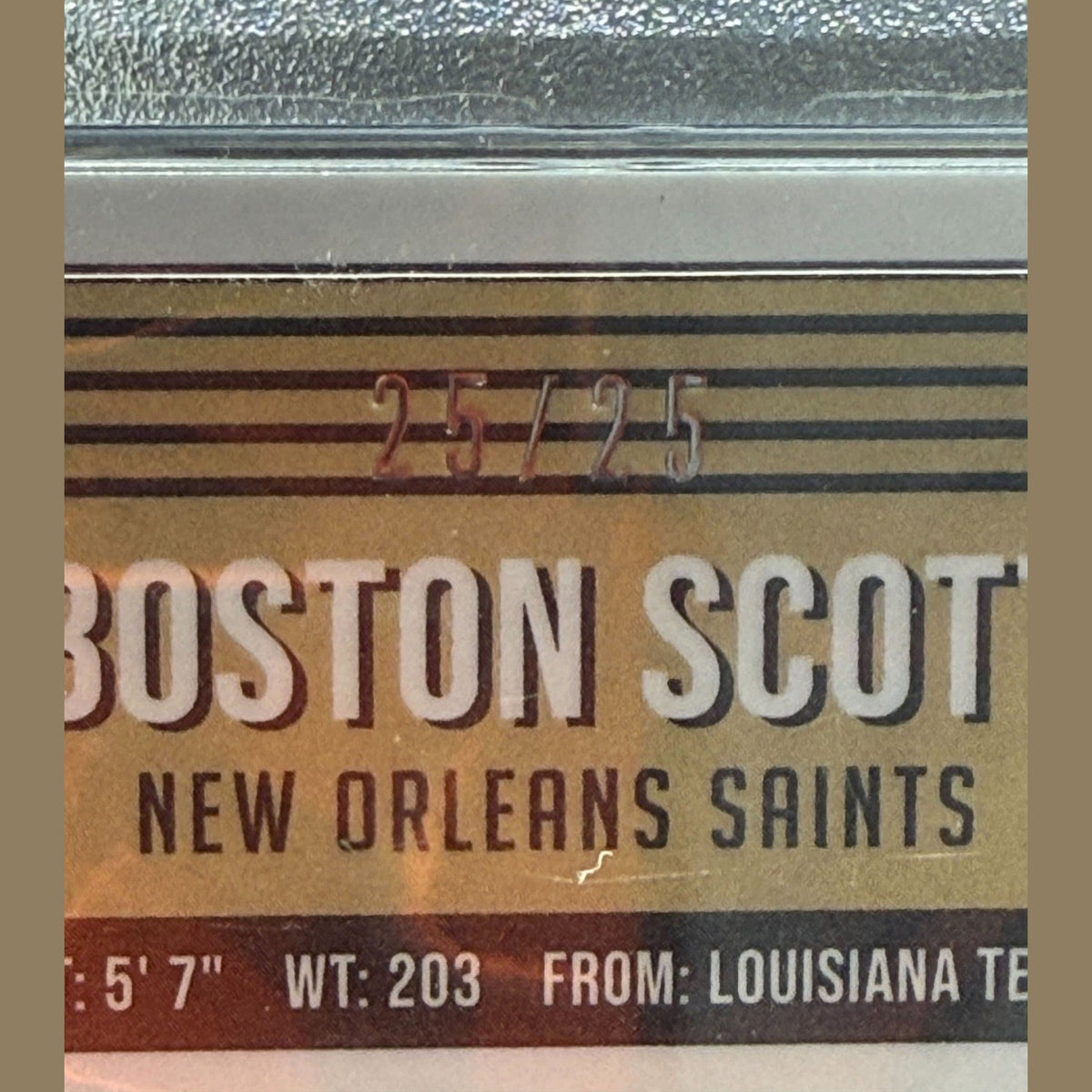 Product label with 'Boston Scott' and 'New Orleans Saints' text on a reflective surface.