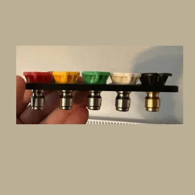 Set of coffee brewing filters with different colors held by a hand against a neutral background