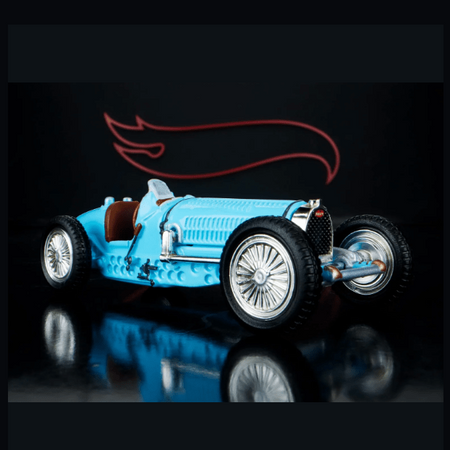 Model car with a blue body and white wheels on a reflective surface, against a dark background.