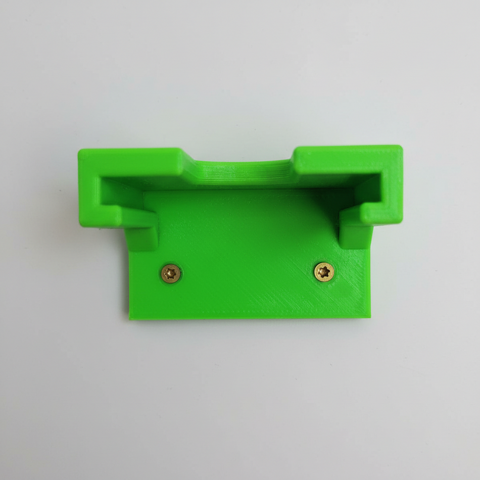 Green plastic bracket on a wooden surface