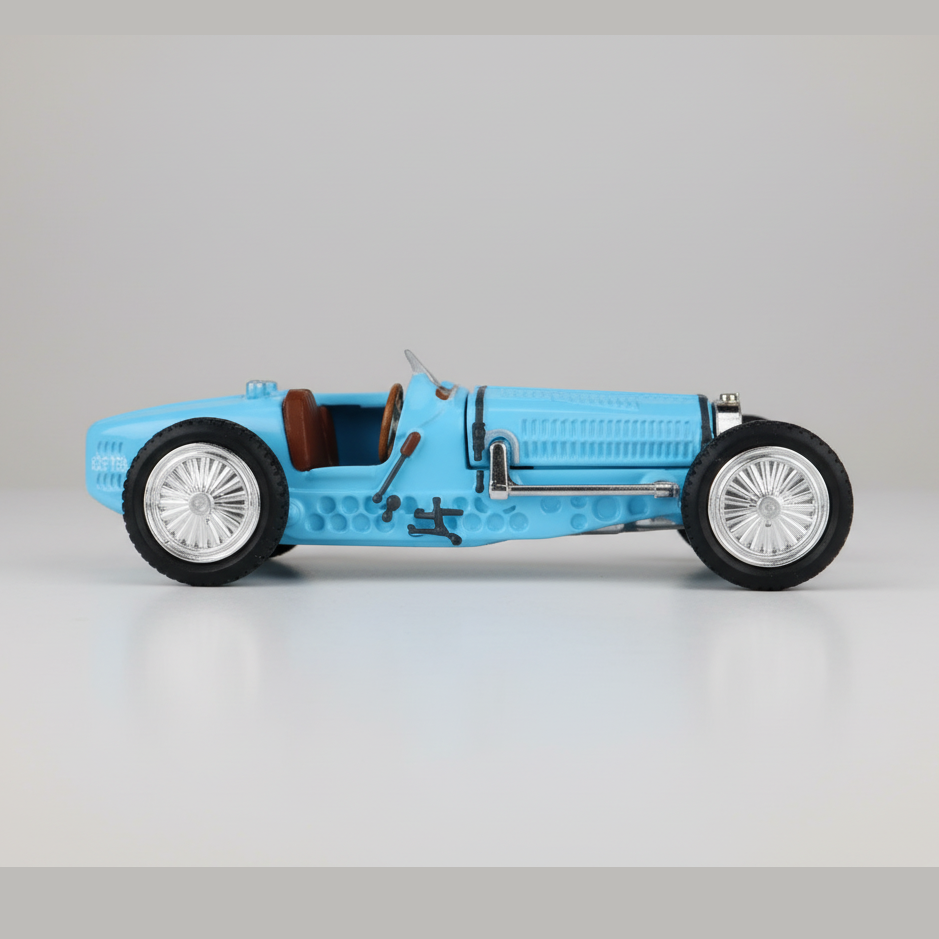 Blue vintage car model on a reflective surface with a dark background