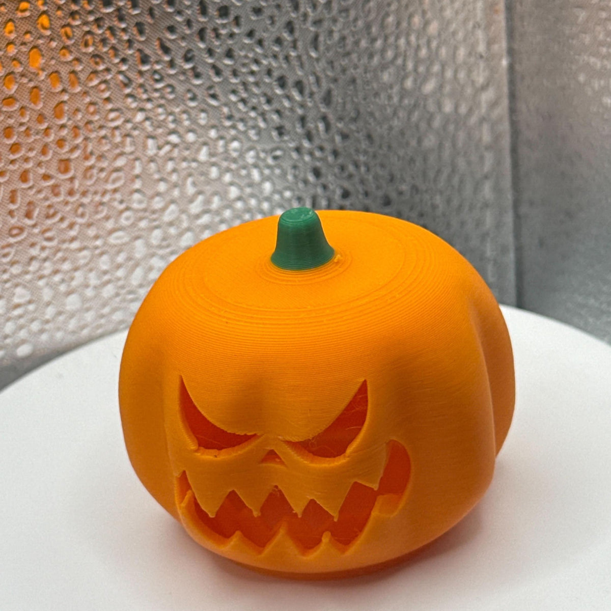 3D Printed Tealight Jack-O-Lantern With Green Stem.