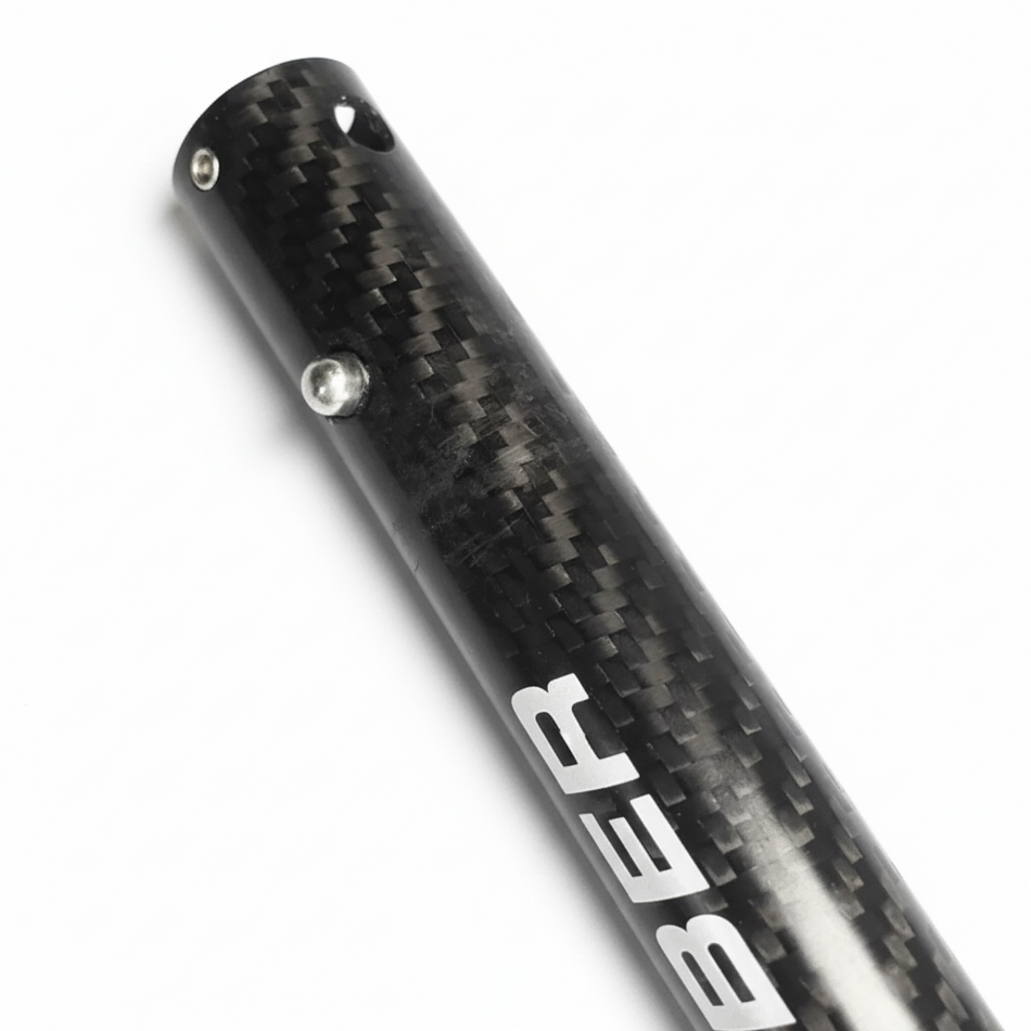 Carbon fiber rod with 'BETA' branding on a brown surface