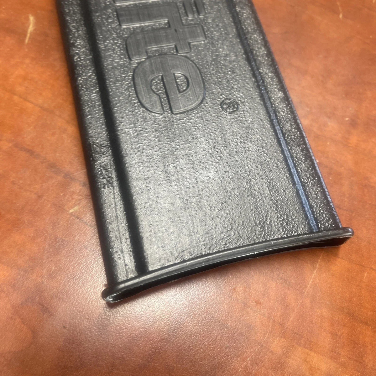 Black gun magazine on a wooden surface