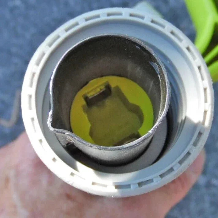 Close-up of a mechanical component held by a hand against a blurred background