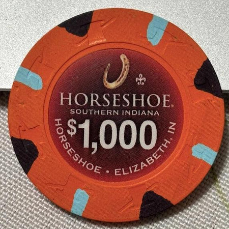 Horseshoe casino chip with $1,000 value on a textured surface