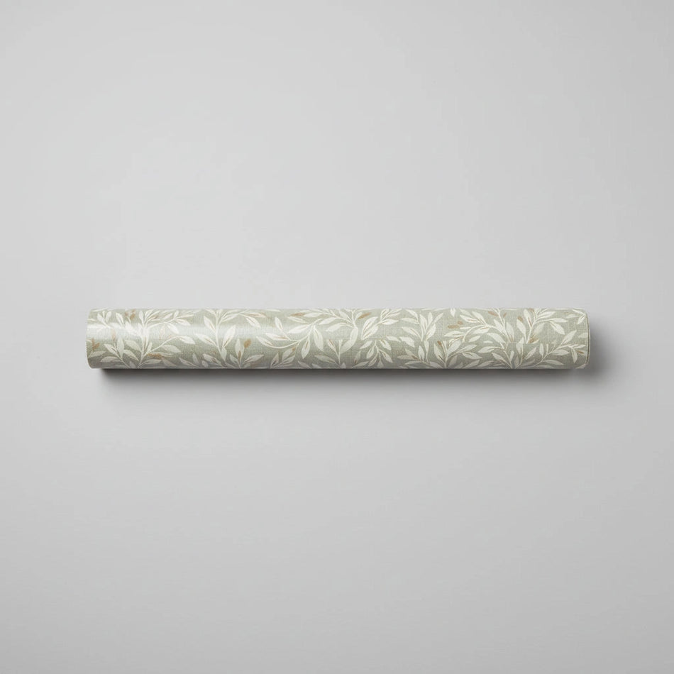 Roll of wallpaper with 'Next' branding on a concrete surface with leaves.