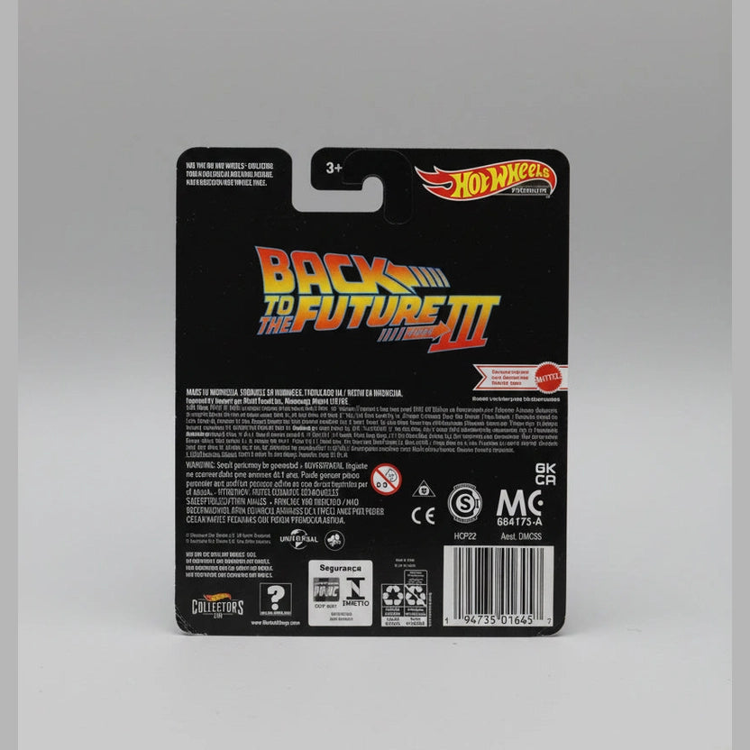 Back of a Hot Wheels toy packaging with 'Back to the Future III' branding on a wooden surface.