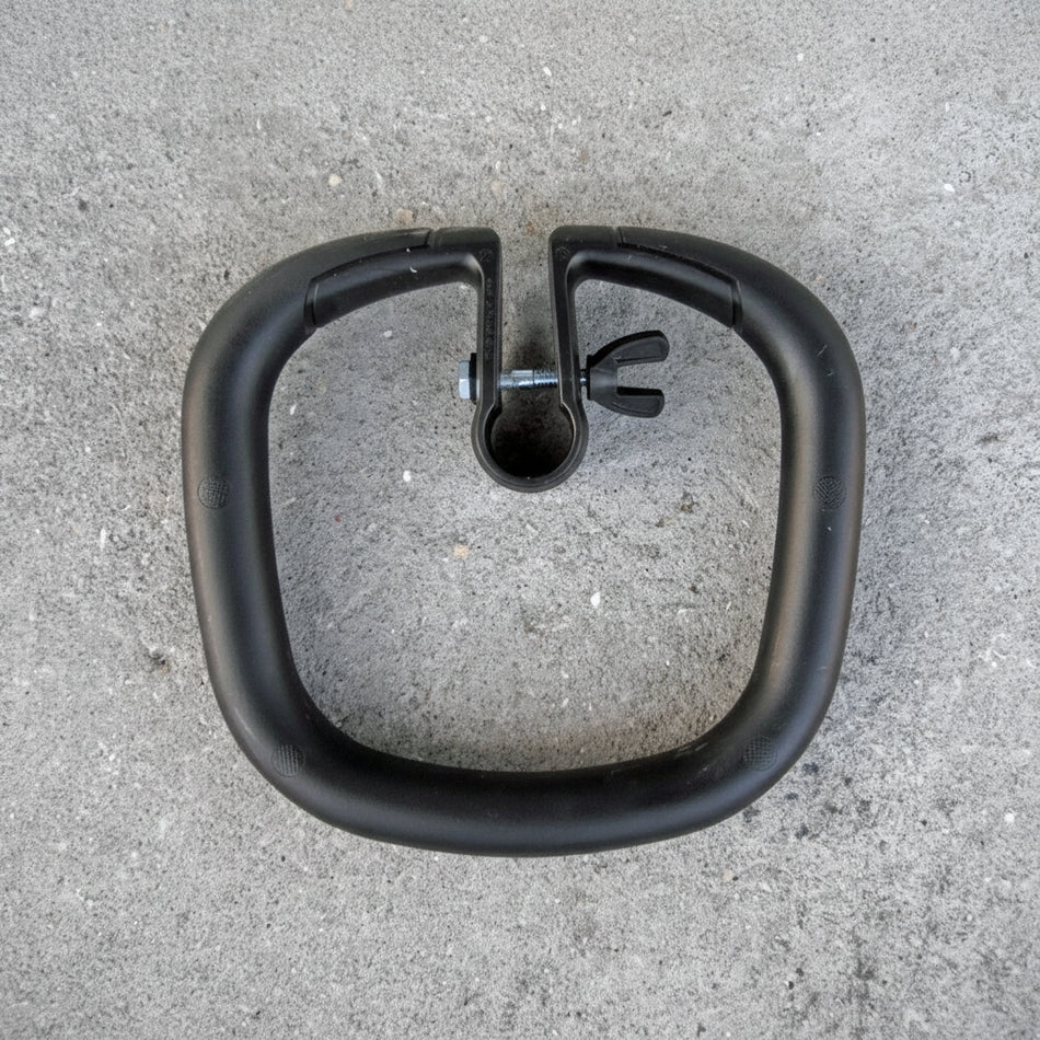Black metal ring with a clip on a gray concrete surface