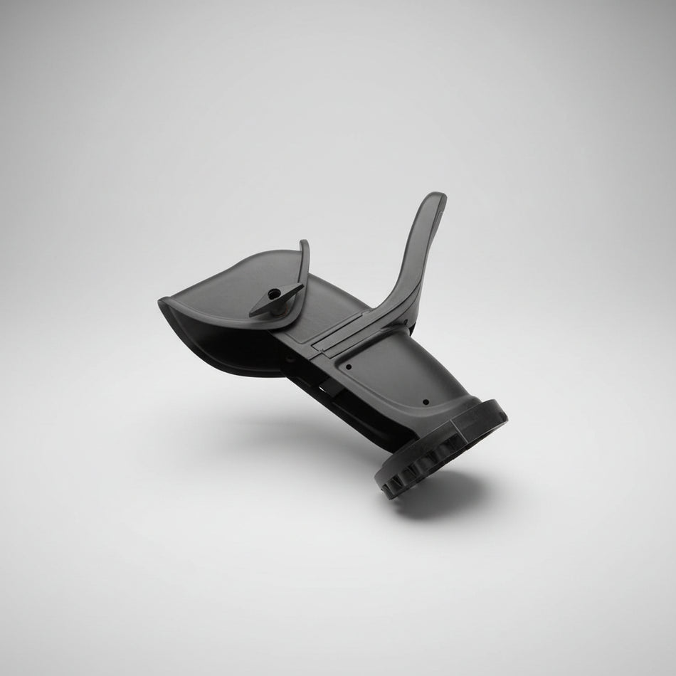 Black plastic component on a wooden floor with a label