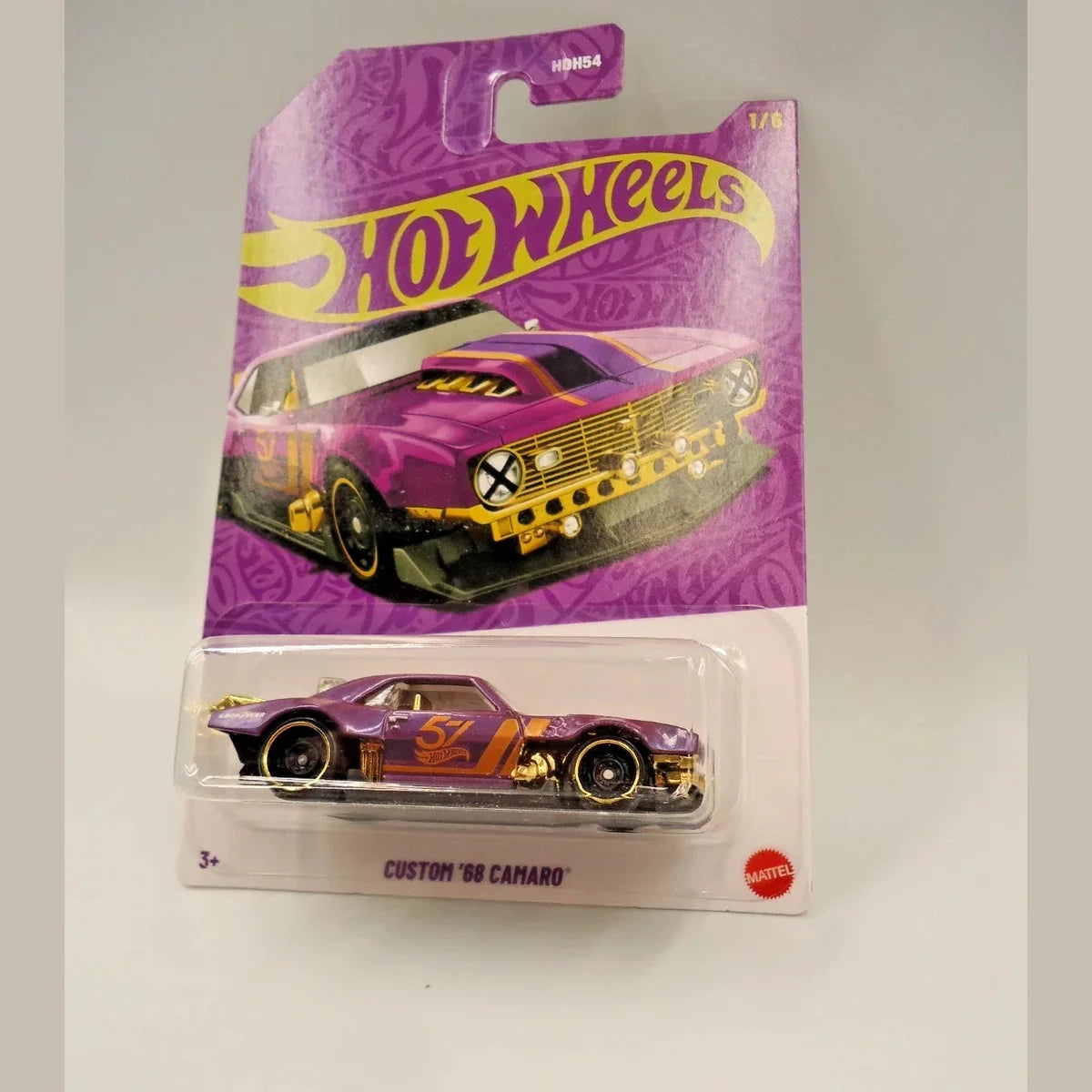 Hot Wheels custom '69 Camaro toy car in purple and yellow packaging on a white background