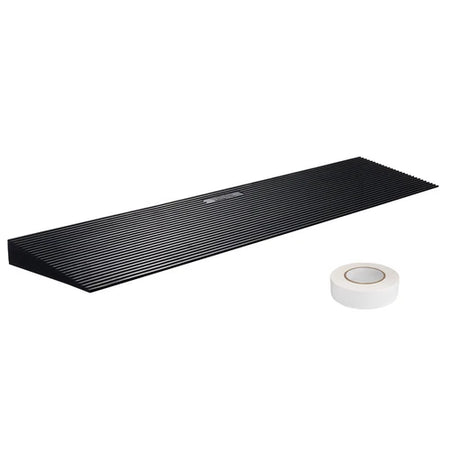 Black rectangular mat with textured surface and a roll of white tape on a white background